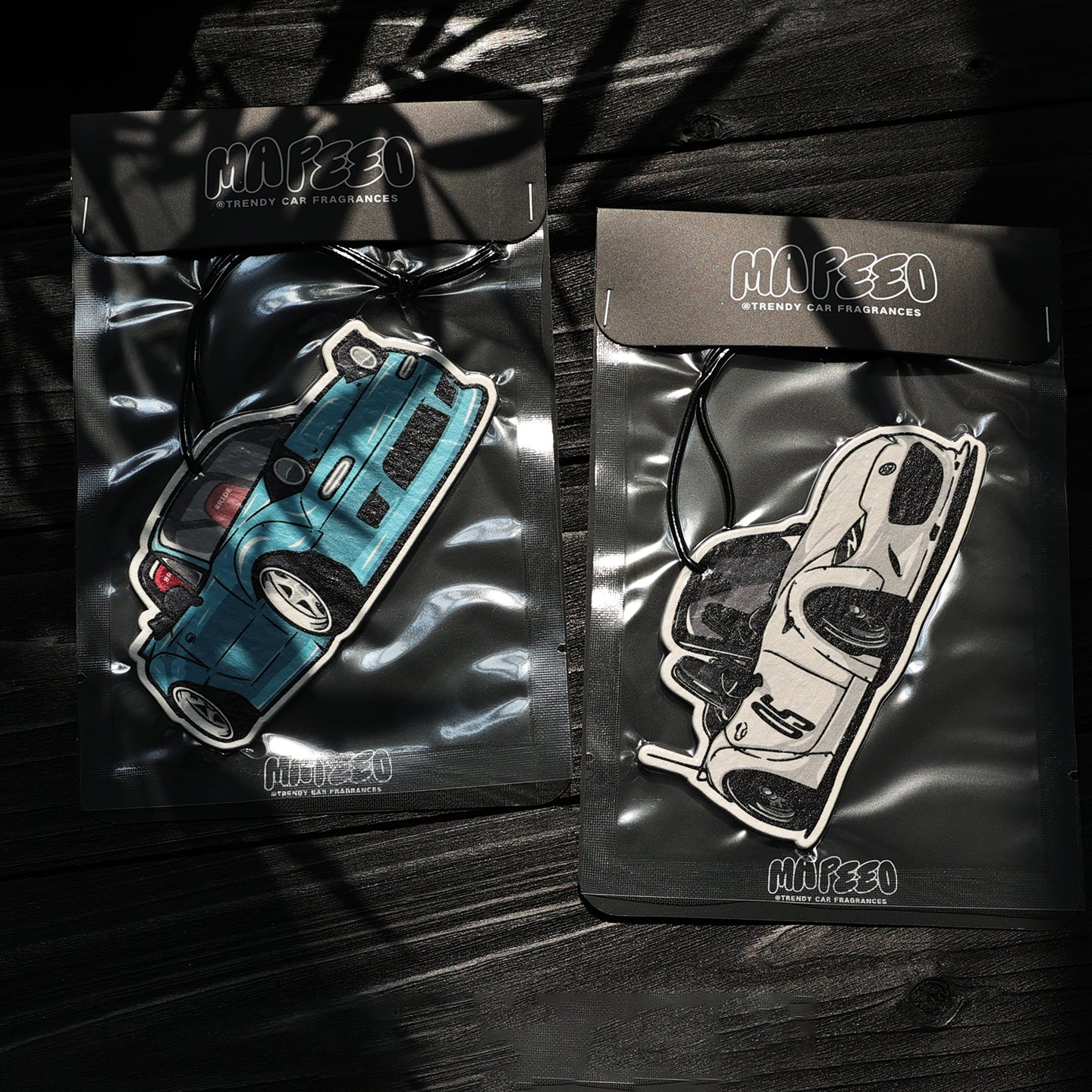 Two packages of Mafeeo car fragrances with car illustrations on a dark background