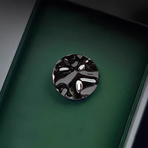 Black decorative object on a green surface