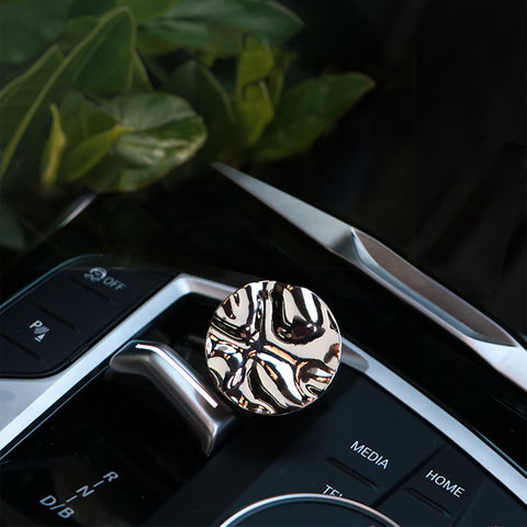 Metallic car air freshener with zebra pattern on a car dashboard