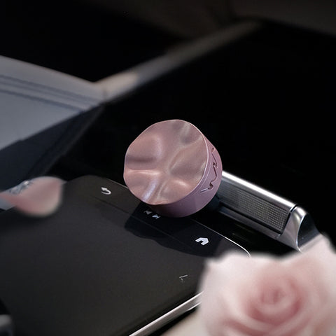 Pink car air freshener on a car dashboard with a blurred background
