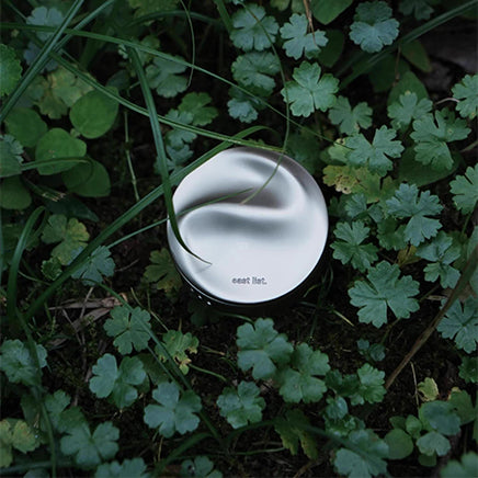 Silver container with 'east list' branding on grass
