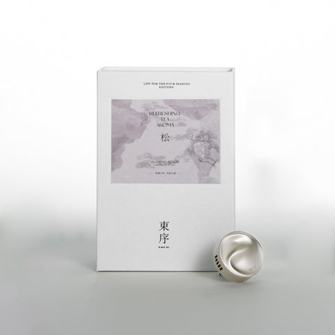 White box with gray design and a silver tea infuser on a light gray background