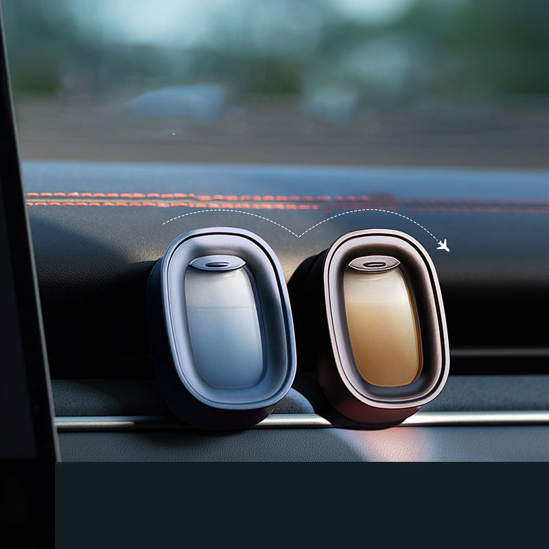 Two car air fresheners on a car dashboard with a blurred background