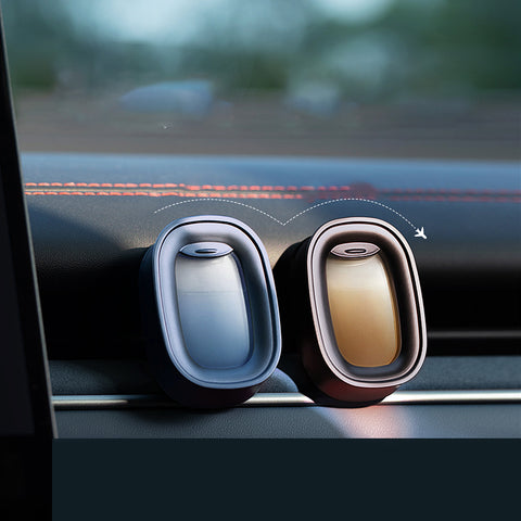 Two car air fresheners on a car dashboard with a blurred background
