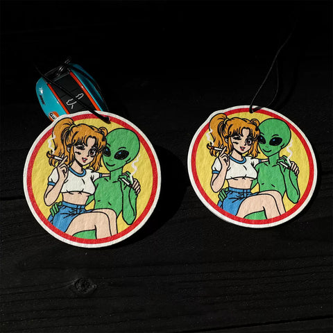 Two round stickers featuring a cartoon character and an alien on a black background.