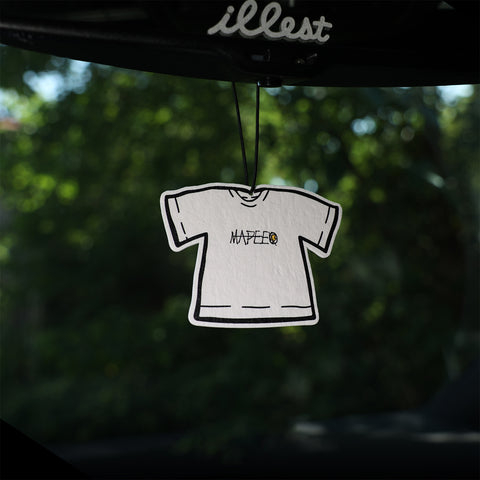 White t-shirt design hanging from a car mirror with 'illest' brand name.