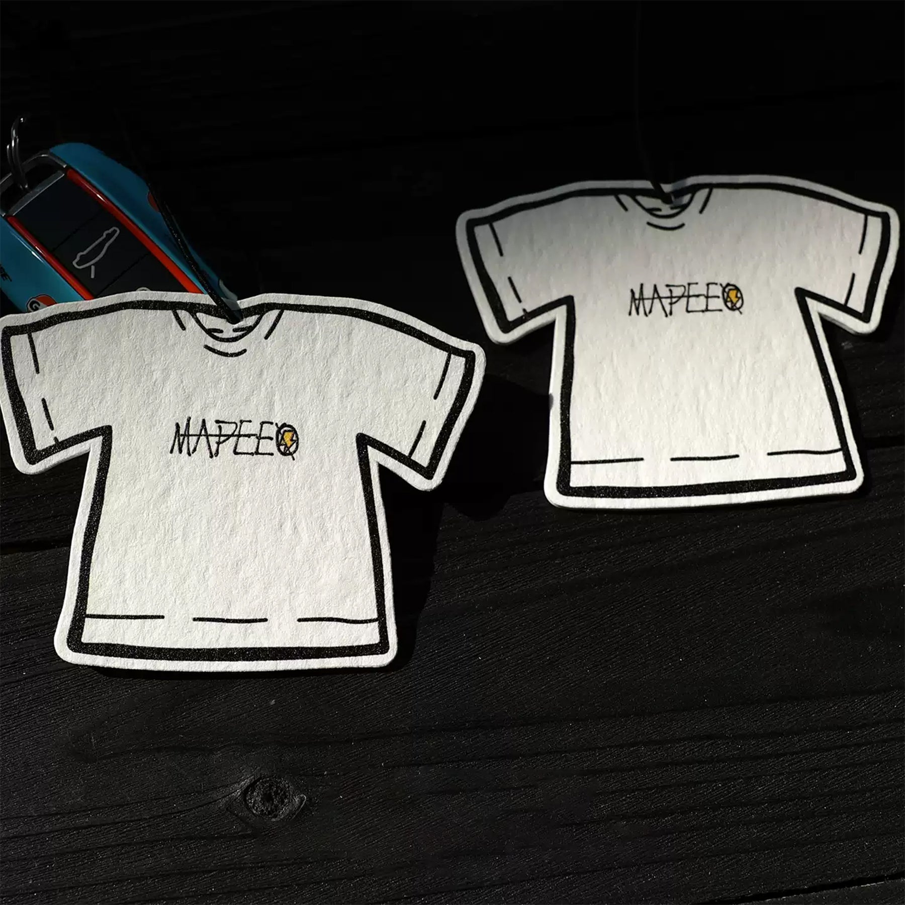 Two white t-shirts with a logo on a black background