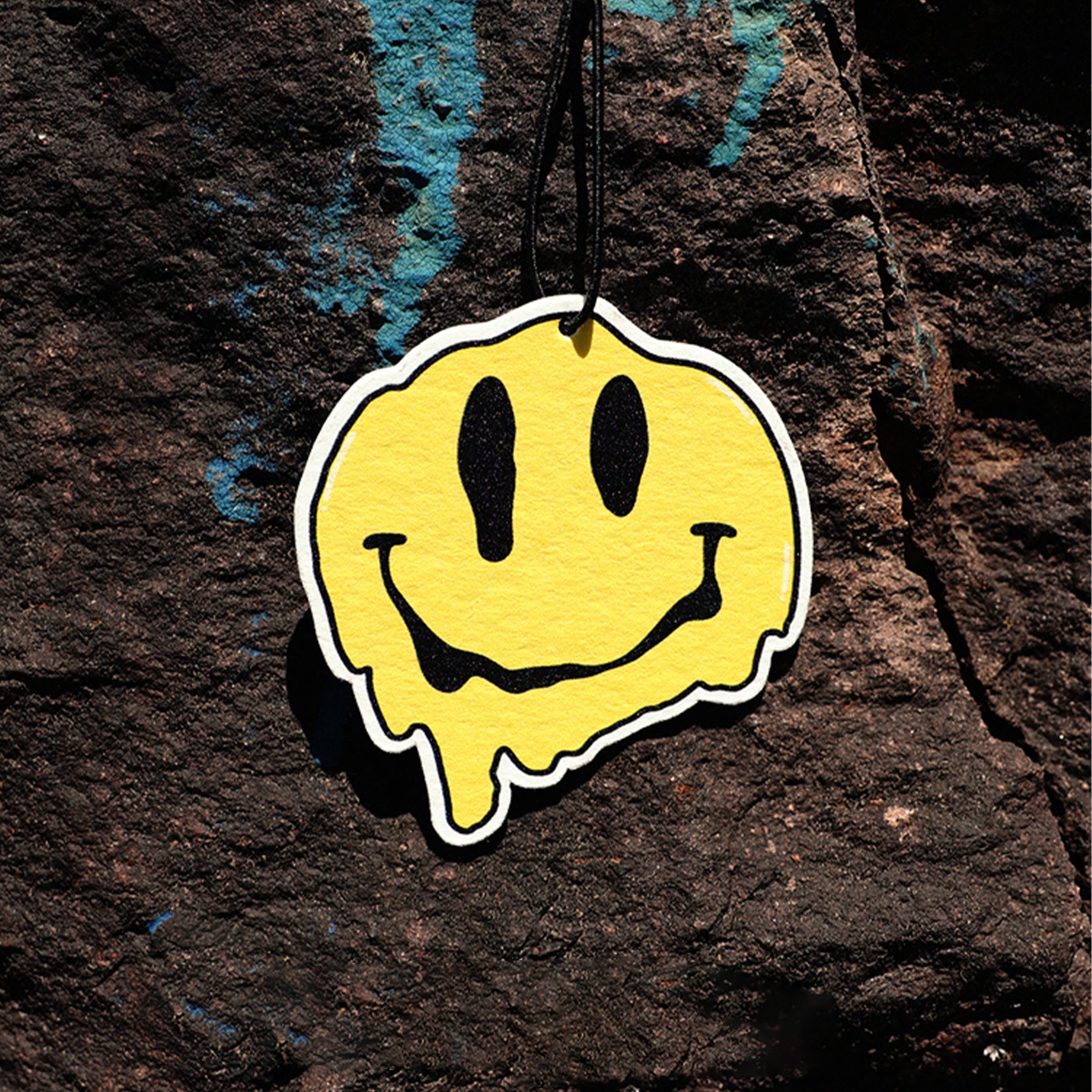 Yellow smiley face sticker on a textured dark surface