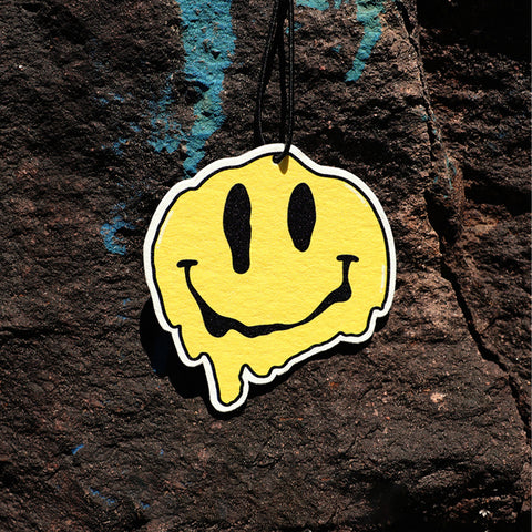 Yellow smiley face sticker on a textured dark surface