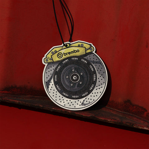 Brembo branded car air freshener on a red surface