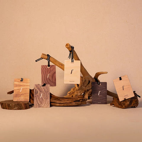 Wooden jewelry display with tags on a beige background
