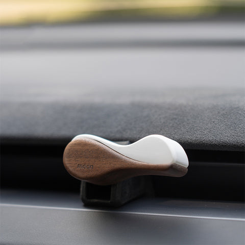 Wooden and white hair clip on a car dashboard