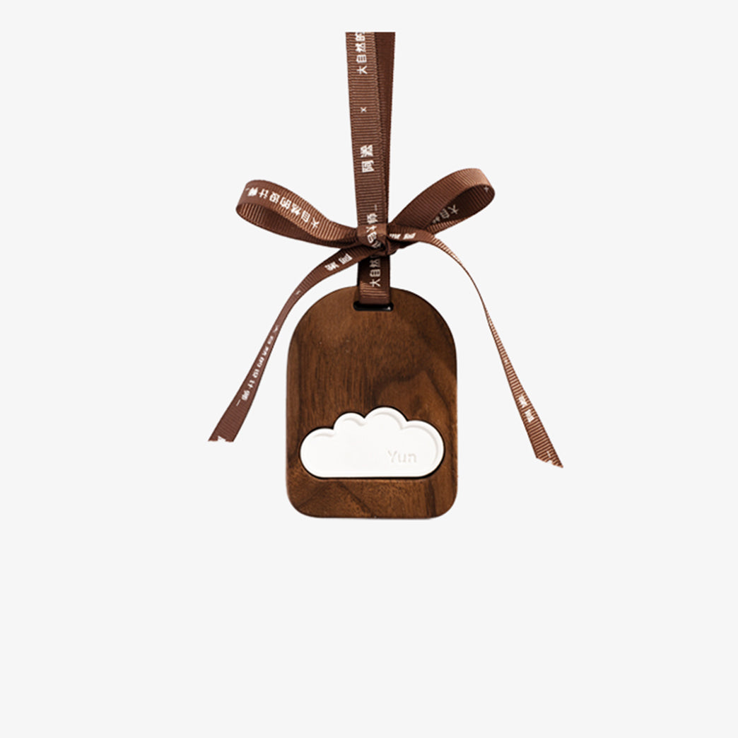 Wooden cloud-shaped bottle opener with a brown ribbon on a white background