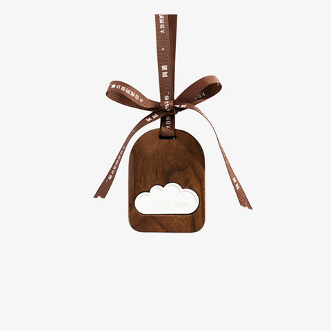 Wooden cloud-shaped bottle opener with a brown ribbon on a white background